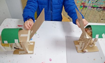 Kind mit selbst entworfenem und gestaltetem Bauwerk