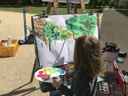 Mädchen malt an einer Staffelei im Schlossgarten