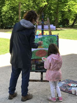 Mutter und Tochter malen an einer Staffelei im Schlossgarten
