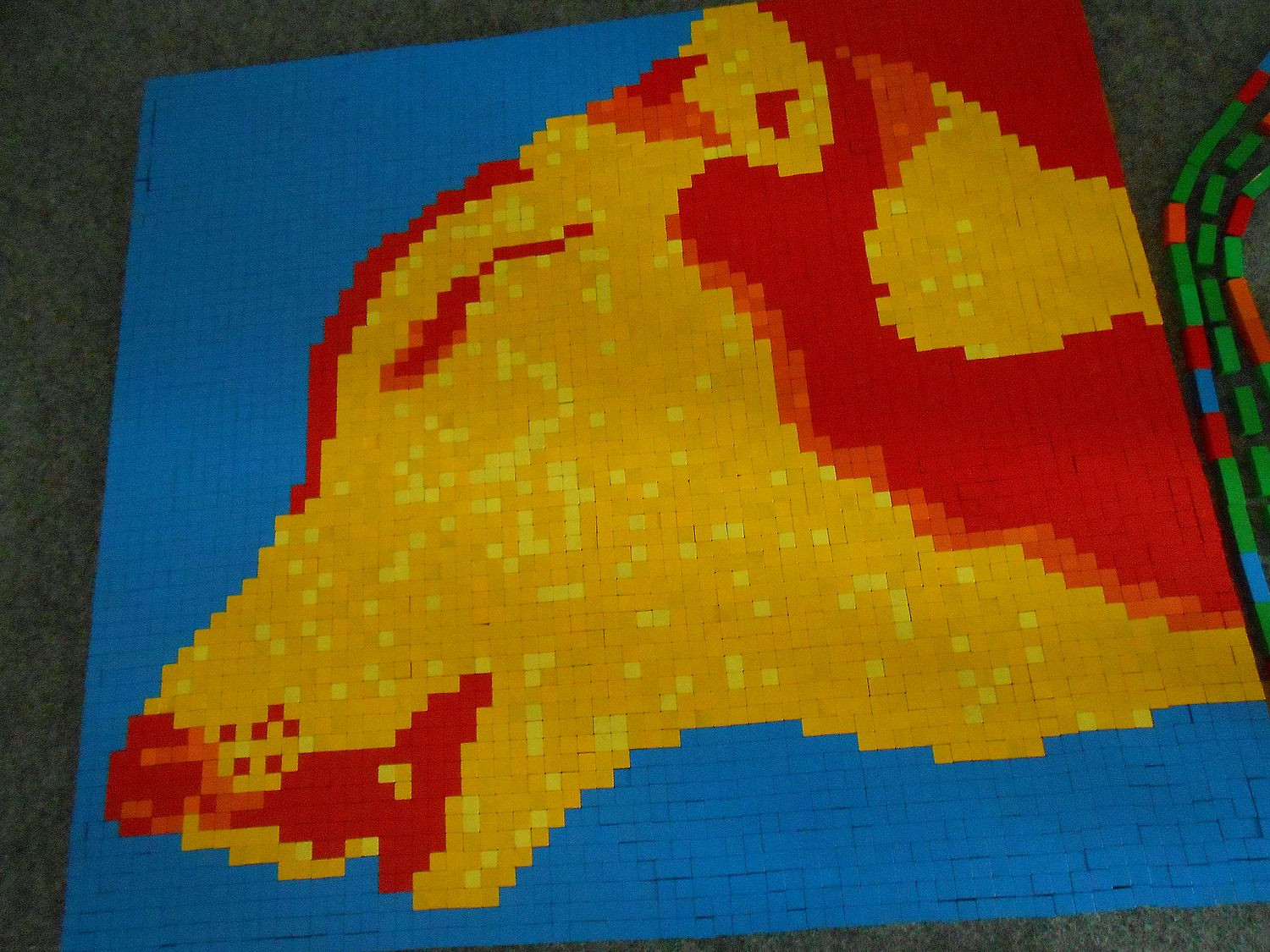 bunte Holzbausteine sind als Mosaik zu einem Bild zusammengesetz. Das Bild zeigt einen Wolf.