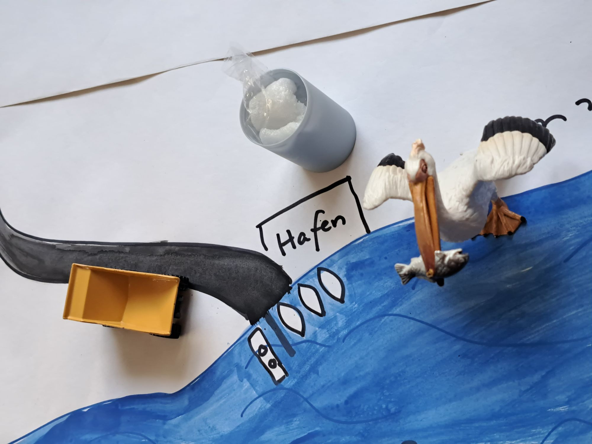 Collage mit Möwe aus Gips und anderen Gegenständen, die einen Hafen darstellen.