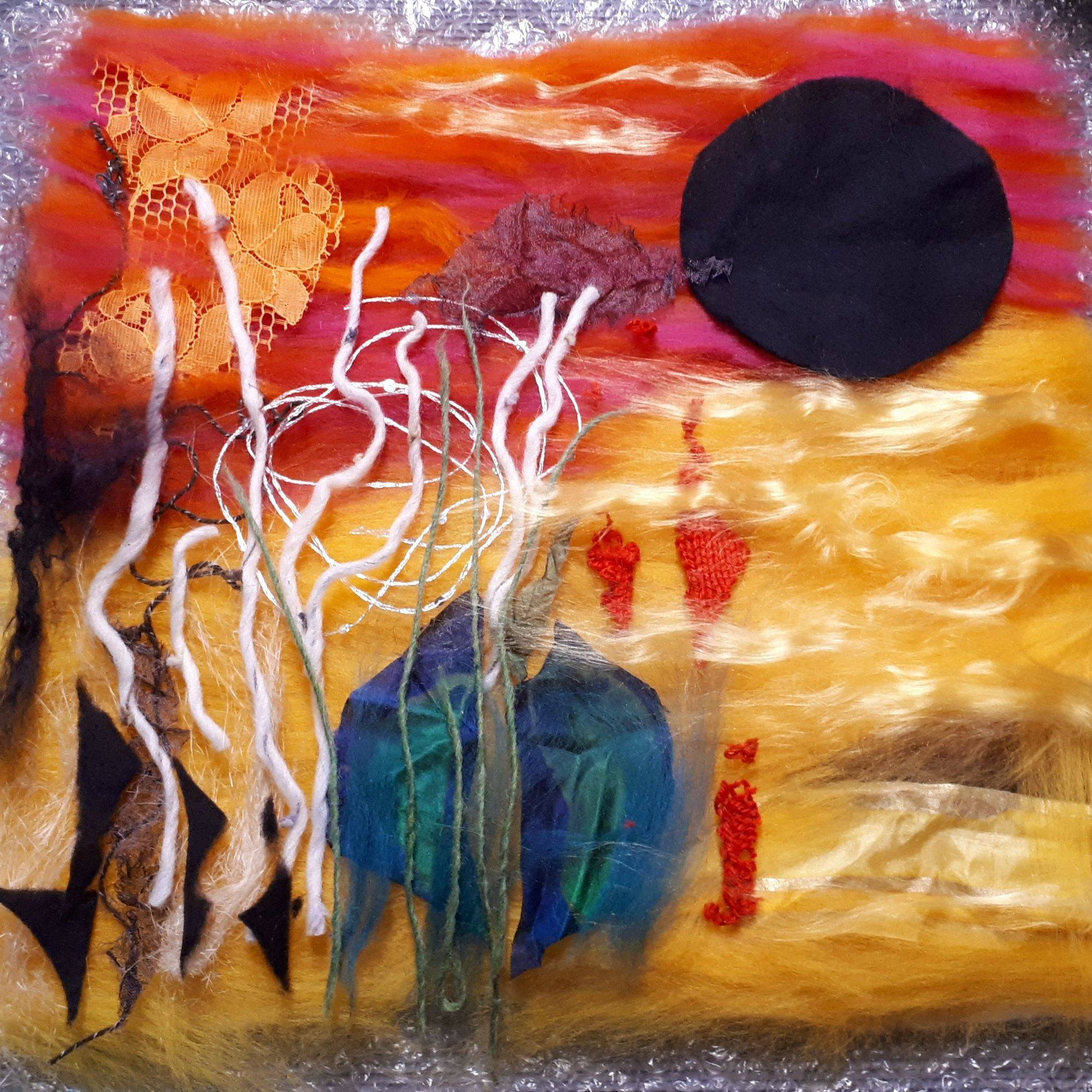 gefilzte Collage mit Spitze und Stoffresten