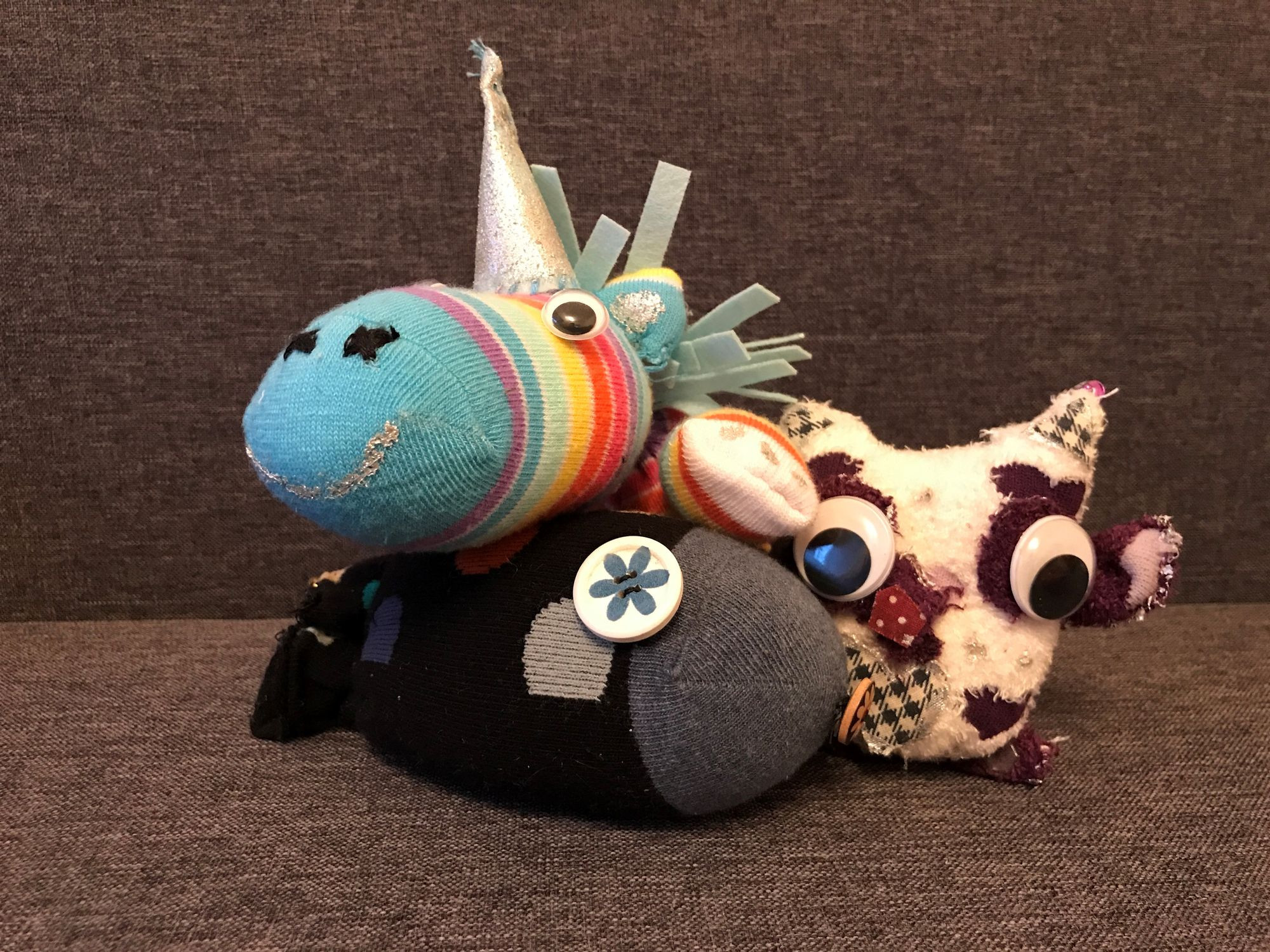 Drei verschiedene Sockentiere, eins davon ist zum Beispiel ein buntes Einhorn.