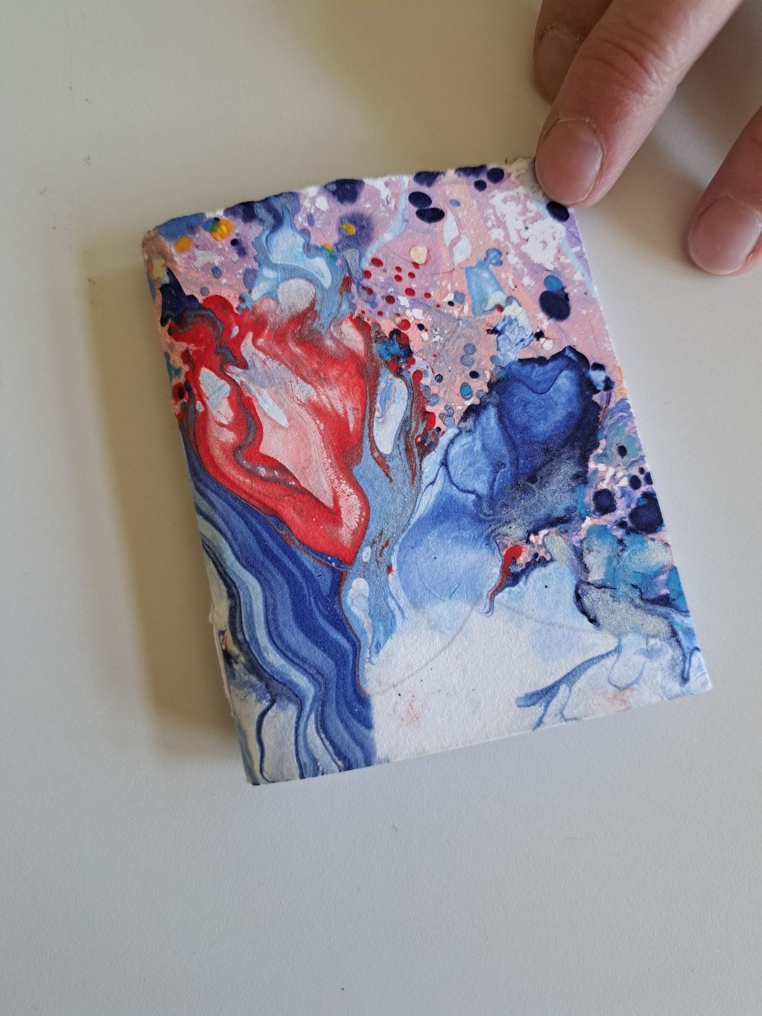 Ein selbstgebundenes Buch mit einem Cover aus marmoriertem Papier.