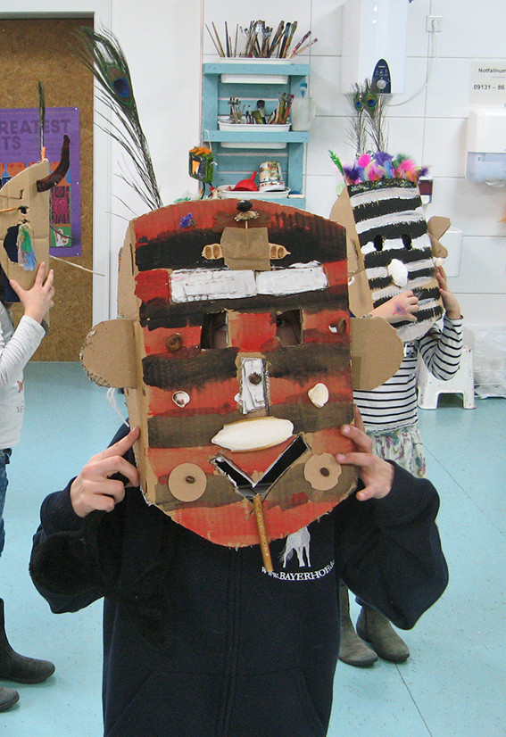 Kinder tragen ihre selbst gestalteten Masken